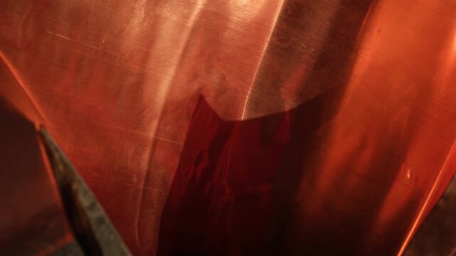 Thin copper sheet, or thin-gauge sheet metal. Warm red and bronze tones. Golden hour sunlight. Random movement.