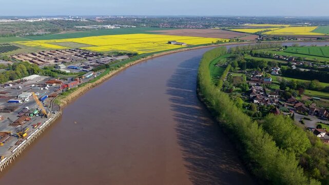 River Trent aerial view with industrial estate and shipping wharf contrasting with rural green fields, UK.