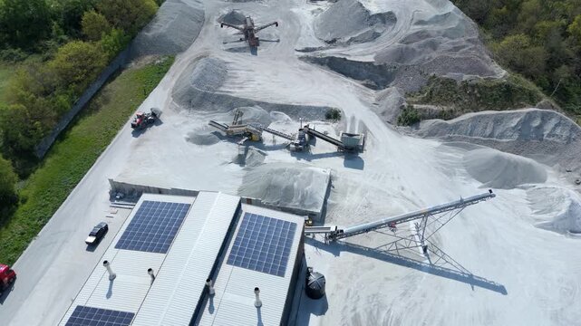 High angle aerial drone view of a heavy plant dumper moving raw materials into a factory hopper in Yorkshire UK