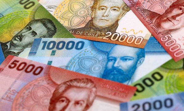 Chilean peso money bills pile on table. Chile banknotes of CLP currency close up.