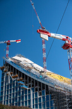 The new skyscraper of CityLife, known as CityWave or nicknamed "the Lying One", is a horizontal building under construction in Milan, workers on the roof working on the construction of the building