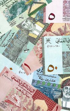 Omani rial money bills pile on table. Oman banknotes of OMR currency close up.