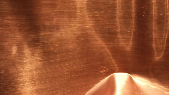 Abstract copper metallic background with warm bronze tones. Sunlight, copper, and shadow. Design backgrounds. Minimal. Selective focus.
