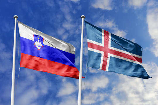 Slovenia and Iceland flags waving in a clear blue sky, symbolizing a powerful diplomacy, expanding global trade, a strategic partnership, and a shared vision of unity for a sustainable future.