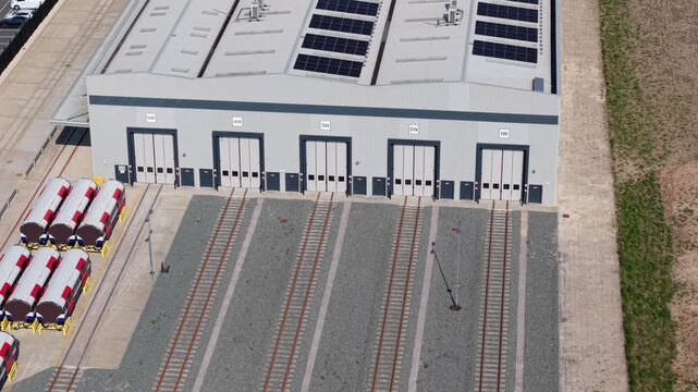 Close up aerial view of a locomotive train workyard with railways rolling into factory doors for maintenance in Goole UK