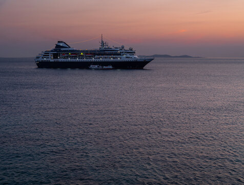 Cruise ship at the port on the island of Mykonos in Greece at sunset