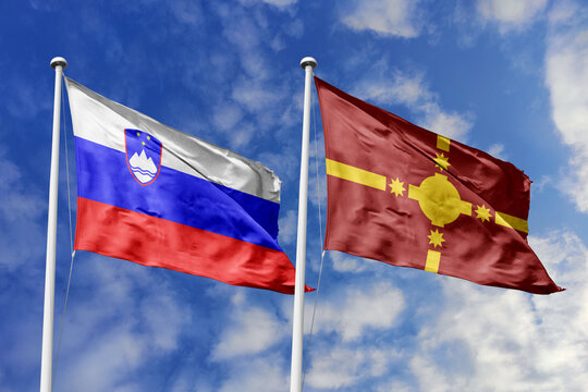 Slovenia and Rotuma flags waving in a clear blue sky, symbolizing a powerful diplomacy, expanding global trade, a strategic partnership, and a shared vision of unity for a sustainable future.