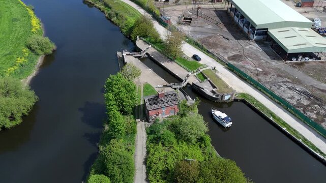 Aerial drone view of a small private yacht waiting for lock gates to open to pass downstream on the River Aire in Knottingley UK