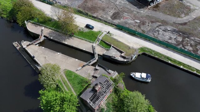 Aerial drone view of a small private yacht waiting for lock gates to open to pass downstream on the River Aire in Knottingley UK