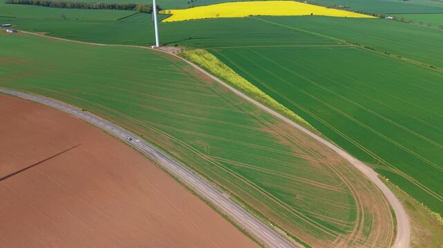 Aerial drone view of Marr Wind Farm wind turbines surrounded by multicolored rural fields and paddocks in Yorkshire UK