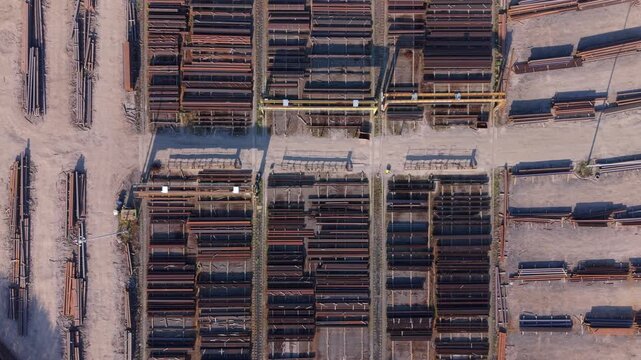 Aerial drone view of raw materials steel beams and iron ore piles stored on a commercial dock near Scunthorpe UK