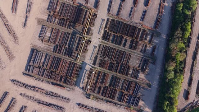 Aerial drone view of raw materials steel beams and iron ore piles stored on a commercial dock near Scunthorpe UK