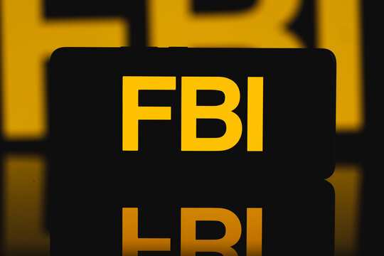 FBI text displayed on a smartphone screen, Federal Bureau of Investigation branding on mobile device for law enforcement, criminal justice, and national security communication