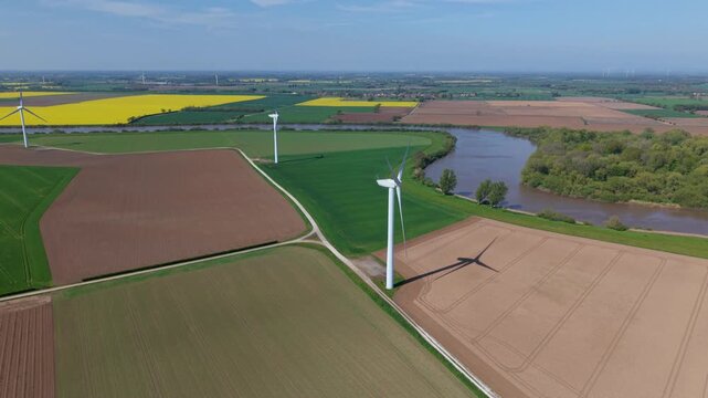High angle aerial drone view of a large onshore wind turbine farm in colorful rural patchwork agricultural fields near Airmyn United Kingdom