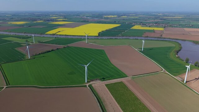 High angle aerial drone view of a large onshore wind turbine farm in colorful rural patchwork agricultural fields near Airmyn United Kingdom