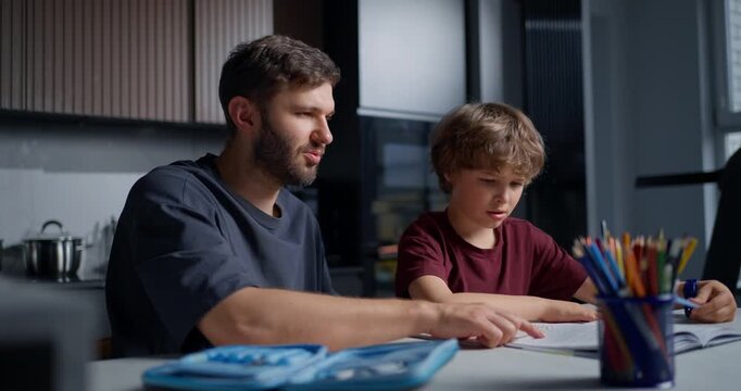 Father And Son Finish Homework Happily Together. Father And Boy Share Proud Educational Moment