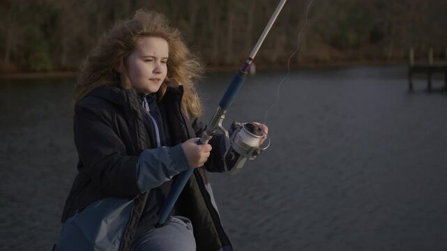 Child explores fishing as hobby. Kid learns fishing skills slowly. Child keeps fishing attention strong. Kid enjoys fishing weekend moment.