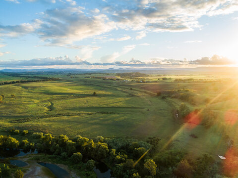 Sunset light over green paddocks with hunter river winding through landscape