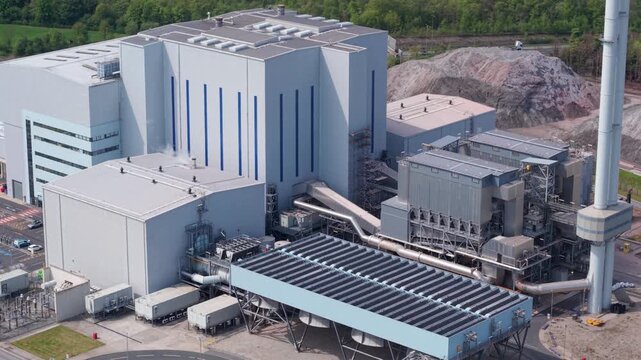 High angle aerial view tracking past twin industrial waste processing plants reducing landfill reliance