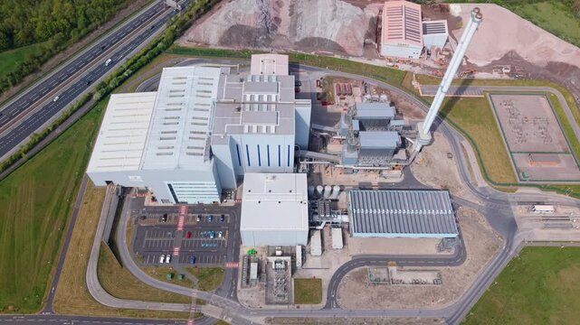 Aerial view of twin modern energy from waste power plants processing municipal refuse for sustainable electricity