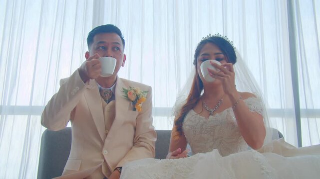A joyful bride and groom sharing a romantic kiss, enjoying their wedding cake, and posing happily on a beautifully decorated stage during their wedding celebration.