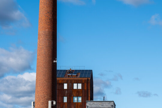 Modern urban industrial rooftop with tall chimney rises into the skyline above Stockholm Sweden as architecture hints at Scandinavian redevelopment in Scandinavia