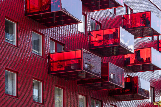 Modern red apartments with balconies and crisp facade architecture in urban Stockholm Sweden highlighting contemporary Scandinavian residential living