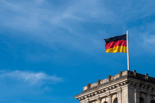 National flag on rooftop in Berlin Germany under daylight sky expressing patriotism symbol beside historic architecture details