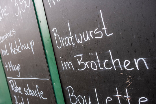 German bratwurst menu on a blackboard in Berlin Germany presents streetfood snack and sausage choices with casual handwriting detail