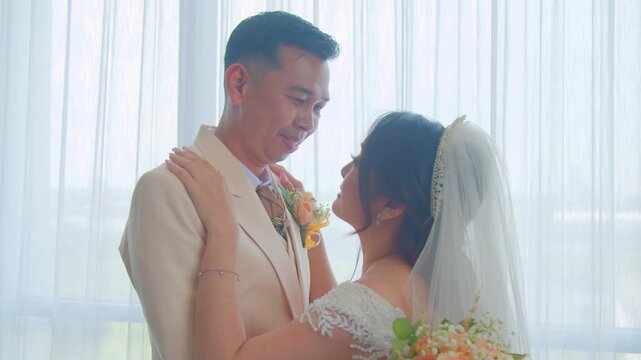 A joyful bride and groom sharing a romantic kiss, enjoying their wedding cake, and posing happily on a beautifully decorated stage during their wedding celebration.