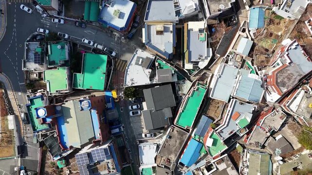 Top view aerial shot of dense residential area with rooftops and narrow streets in Busan, South Korea. Urban pattern, compact housing and city layout.