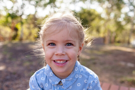 Portrait of happy 3yo girl outdoors with blue denim dress