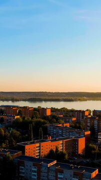 Vertical video. Russia, Votkinsk. Embankment with a dam and factories. Votkinsk is a city in the Udmurt Republic. Sunset time. Drone footage. Rich colors
