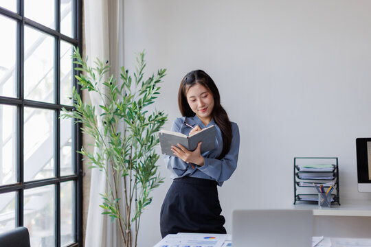 Businesswoman writing notes in office, planning, productivity