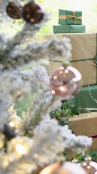 Vertical video: Pulling cam back revealing holiday scene by window with frosted firs, wrapped gifts