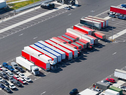 Aerial view of a row of trucks and trailors lined up in a transit carpark