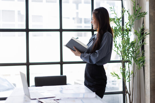 Businesswoman standing in office reviewing documents