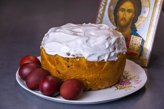 Traditional Orthodox Easter Kulich Cake with Red Eggs and Christ Pantocrator Icon on Grey Background