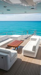 Fototapeta premium Luxury yacht deck with white seating and wooden table overlooking turquoise ocean waters on a sunny day