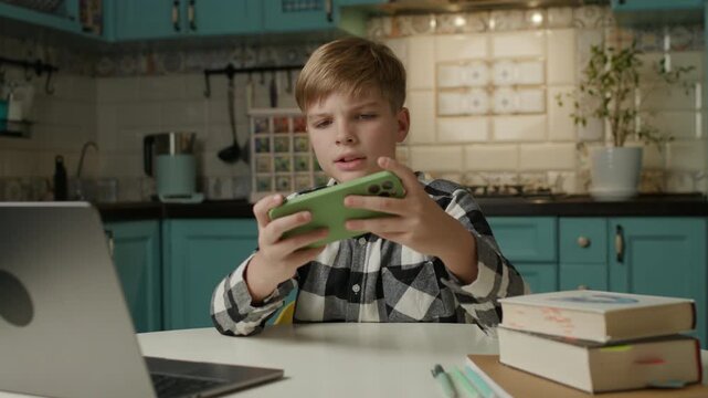 Boy Playing Mobile Games and Reacting Emotionally