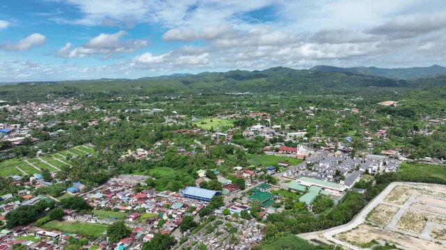 Land grabbing residential and commercial districts Danao Cebu Philippines mountain over populated population cluster of building and houses poor people squatter clear sky green trees mountain forest