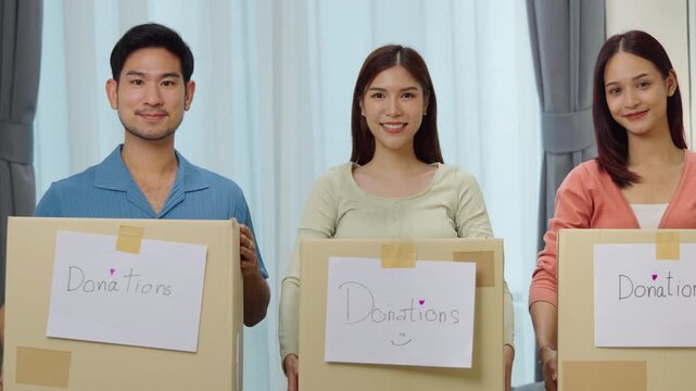 group of asian young adults tanding together, each holding a donation box with a handwritten sign. community support, and charitable giving