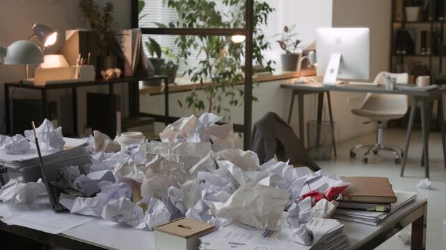 No people shot of desk covered with pile of crumpled paper documents in modern office workspace