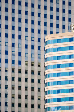 Closeup of blue and white curved office tower geometry architecture facade office corporate urban abstract glass pattern modern district detail