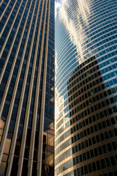Upward view of converging glass towers with glare architecture facade office corporate urban abstract glass pattern modern district perspective