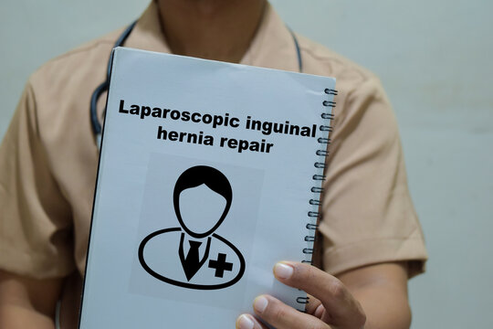 Doctor holds in hands a book with the name of the laparoscopic inguinal hernia repair. Medical concept