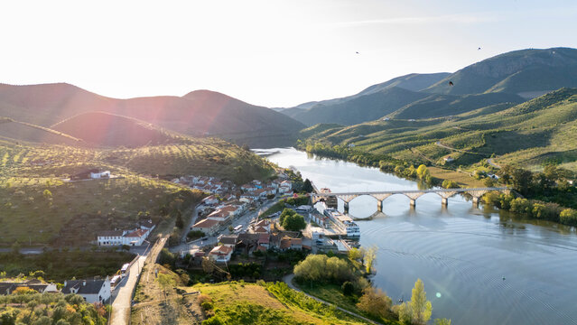 Douro river village with bridge and green hills at sunset