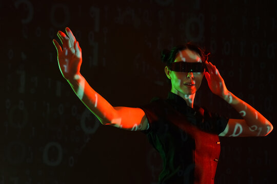 Young woman in VR glasses with projection of program code on dark background