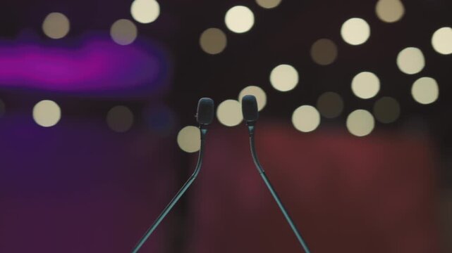 Dual Conference Microphones on Podium with Blurred Audience Background