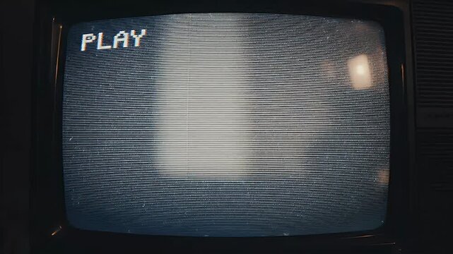 A vintage television screen displays static and the word 'PLAY', evoking a sense of nostalgia and technological obsolescence.